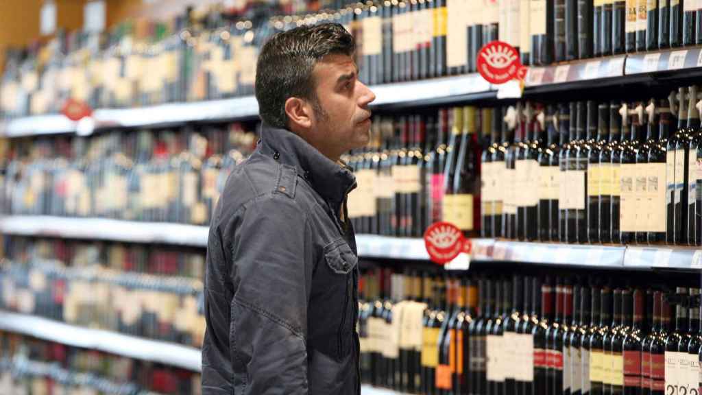 Un hombre observa los precios de los vinos en las estanterías de un supermercado de Valladolid