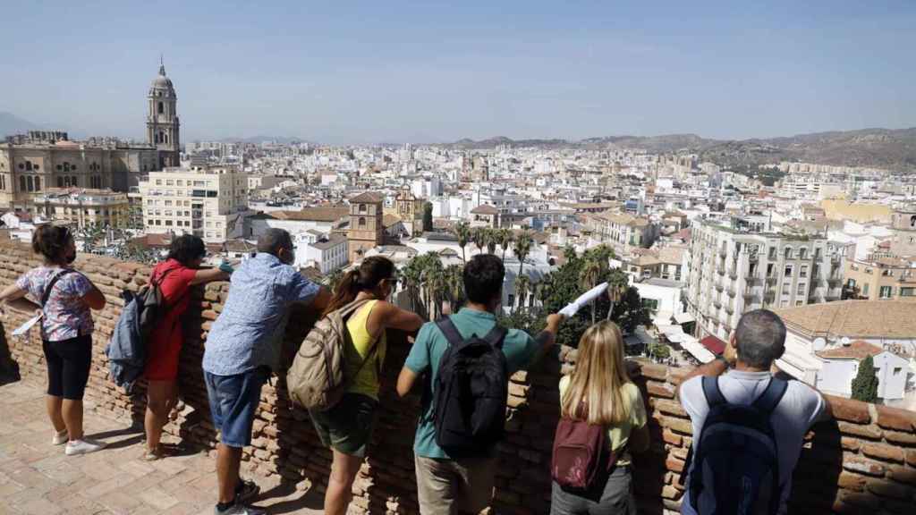 Un grupo de turistas observan Málaga desde el mirador de La Alcazaba.