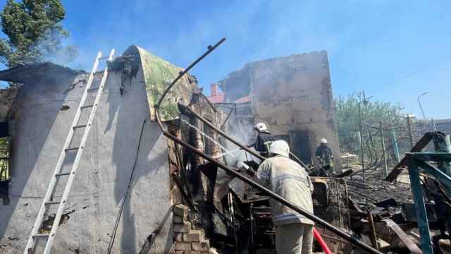 Varios bomberos trabajan en Odesa junto a las ruinas del edificio atacado por Rusia este lunes 16 de mayo