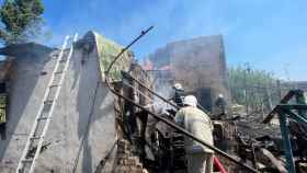 Varios bomberos trabajan en Odesa junto a las ruinas del edificio atacado por Rusia este lunes 16 de mayo