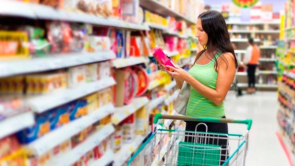 Una mujer comprando productos de higiene íntima femenina como las compresas.