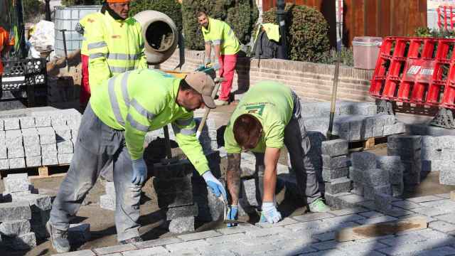 Unos trabajadores renuevan el pavimento en una calle del Casco Histórico de Toledo.