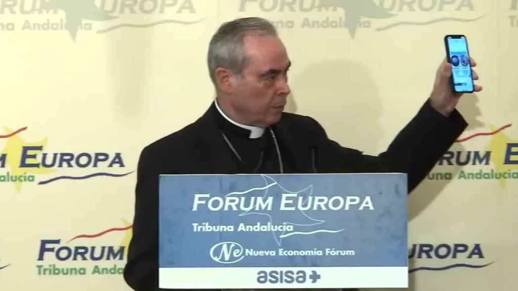 El obispo de Málaga, Jesús Catalán, muestra un mensaje en su teléfono móvil.