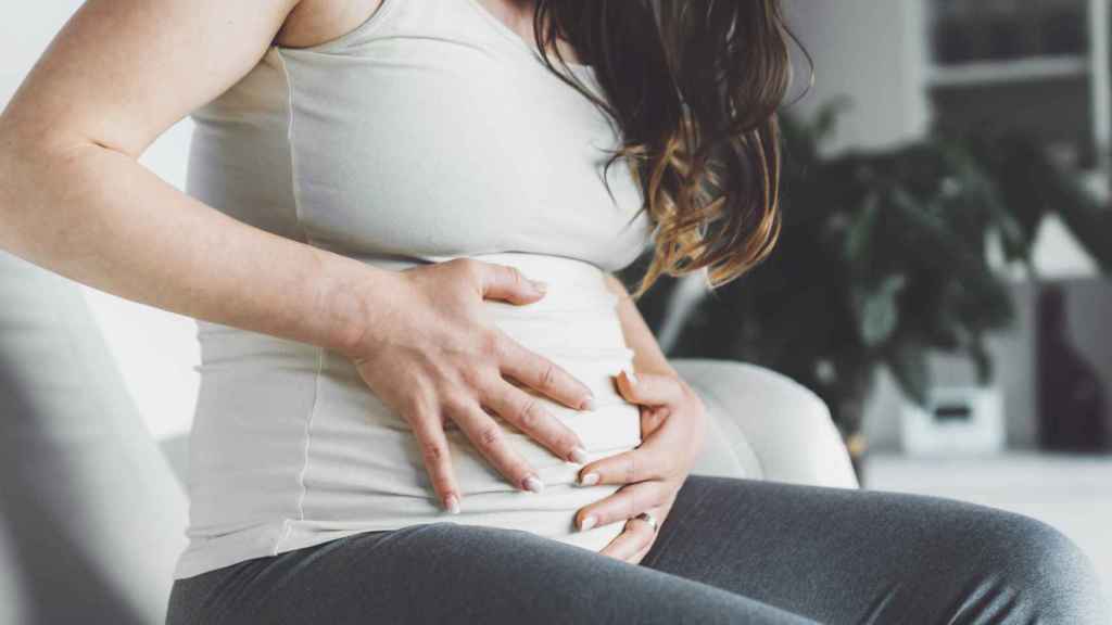 Mujer embarazada tocándose el vientre.