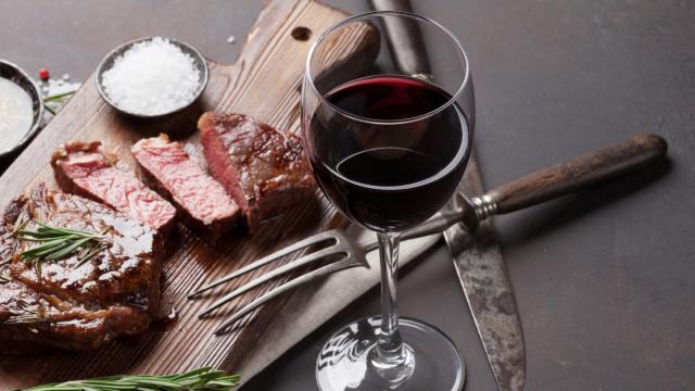 Rodajas de carne roja poco hecha y una copa de vino.