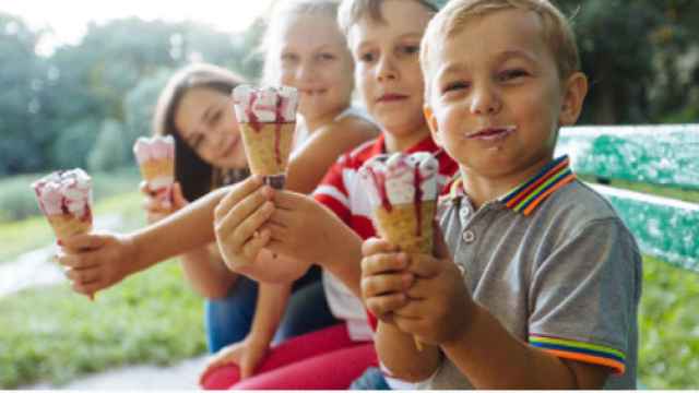 Cuatro niños comiendo helados.