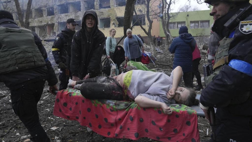 Empleados y voluntarios de emergencia ucranianos llevan a una mujer embarazada herida desde el hospital de maternidad destruido por los bombardeos en Mariúpol, Ucrania, el 9 de marzo .
