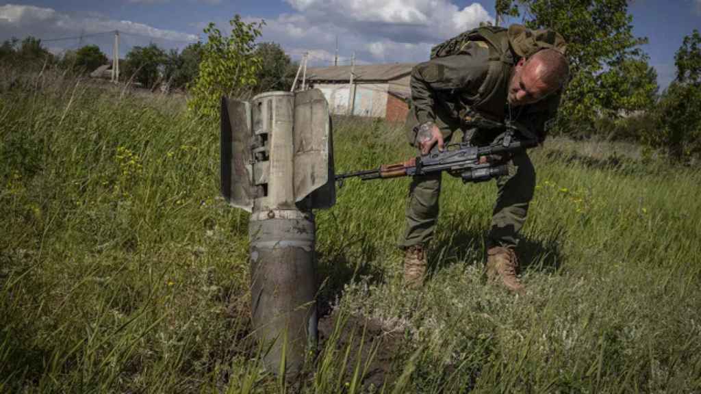 Un soldado ucraniano junto a un misil ruso sin detonar.