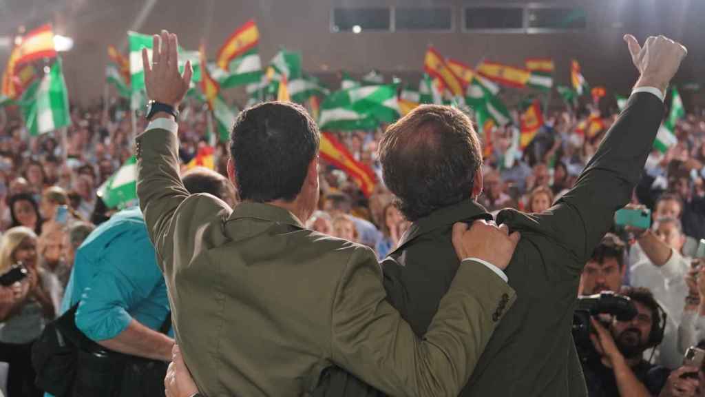 El presidente del PP, Alberto Núñez Feijóo, y el de la Junta de Andalucía, Juanma Moreno, sobre el escenario en un acto en Sevilla.