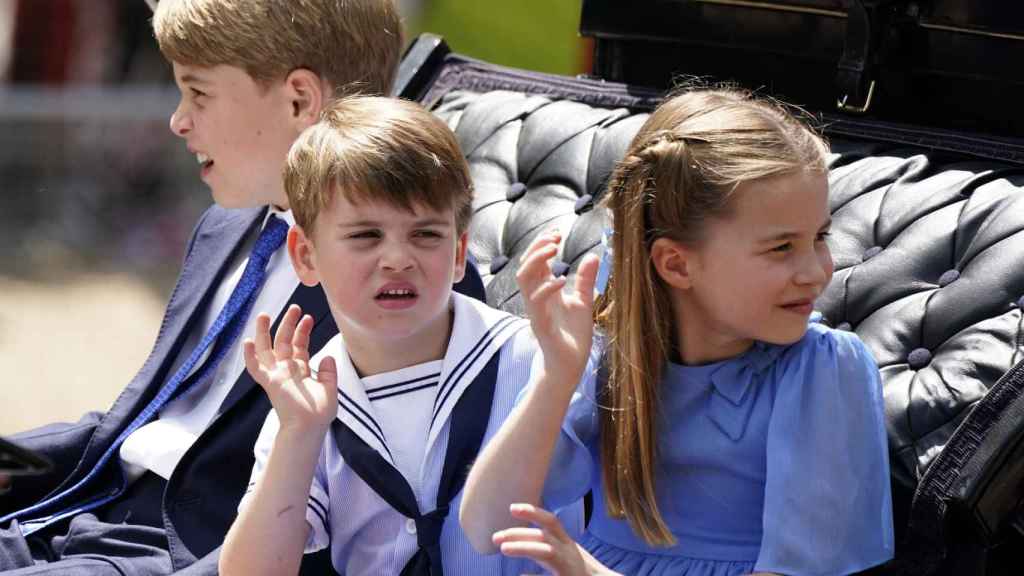 Los hijos de los duques de Cambridge saludan desde la calesa.