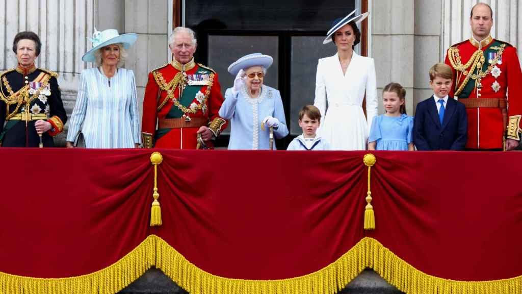Isabel II saluda desde el balcón con su familia.