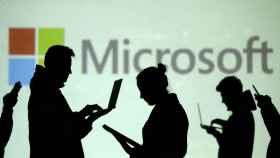 Varias siluetas de personas delante del logo de Microsoft.