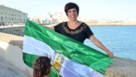 Teresa Rodríguez, junto al mar, con la bandera andaluza y una de sus hijas.