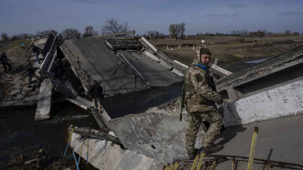 Un soldado se para en un puente destruido por el ejército ucraniano para impedir el paso de tanques rusos cerca de Brovary,