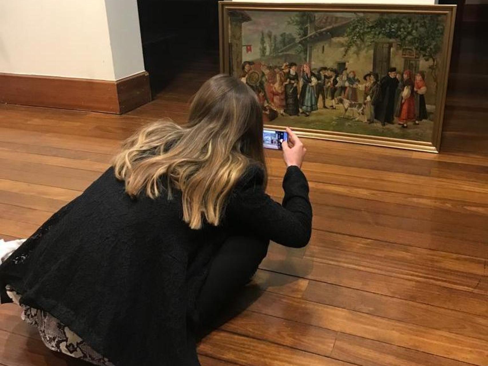 Una mujer fotografía un cuadro en una imagen facilitada por la ULE.