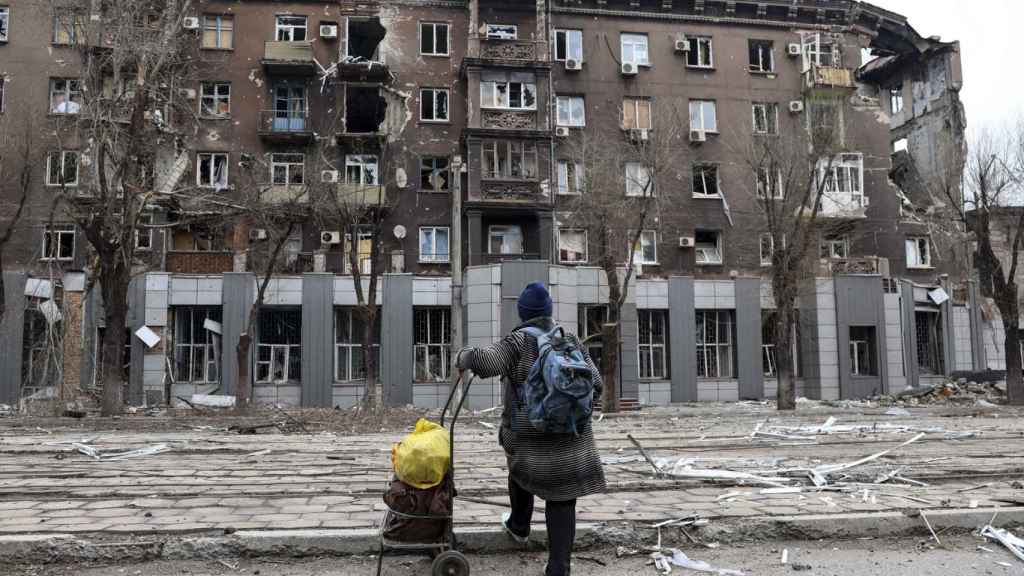 Un residente local mira un edificio de apartamentos dañado durante un bombardeo en Mariúpol.