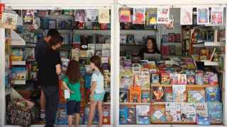 Dos niñas escogen libros en la Feria del libro de Madrid.