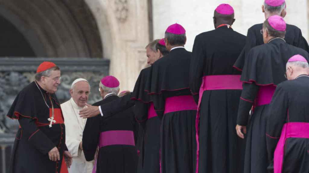 El papa Francisco y el cardenal Raymond Leo Burke saludando a los obispos.