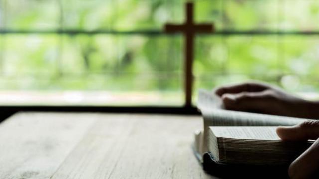 Imagen de archivo de una persona con un libro religioso.