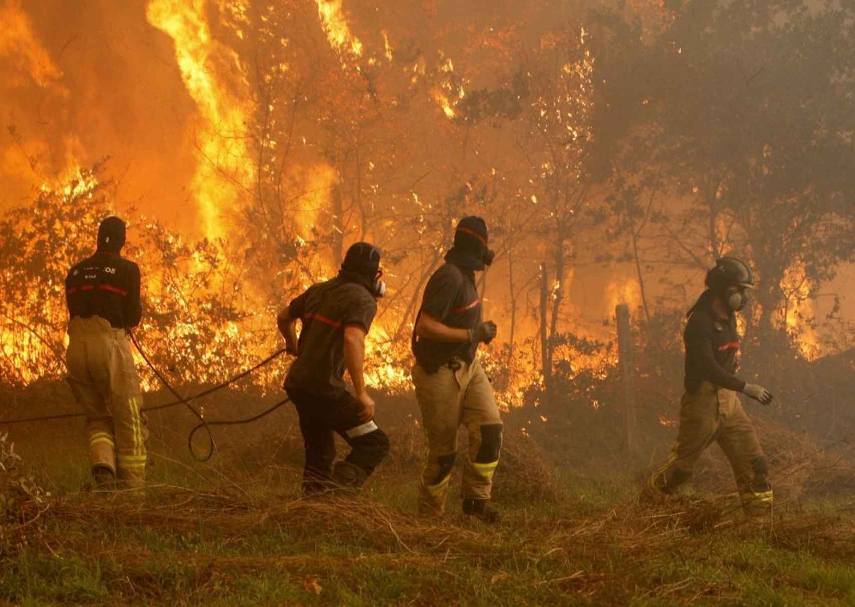 Operarios de los servicios de extinción de incendios trabajan en la zona de Zamanes, Vigo.