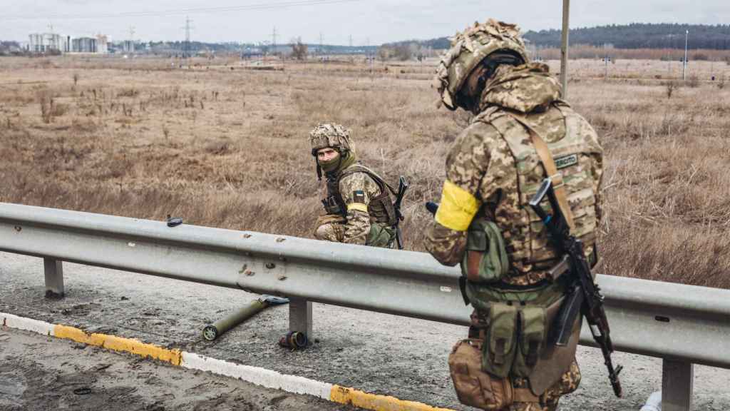Dos soldados del ejercito ucraniano caminan por una carretera.
