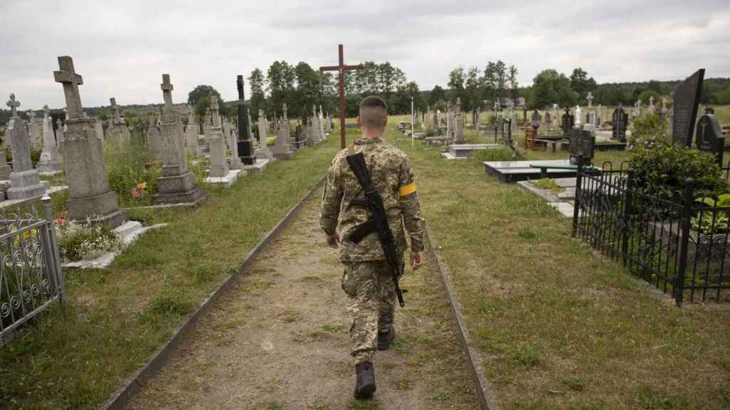 Un soldado camina por el cementerio durante las ceremonias fúnebres de un soldado ucraniano.