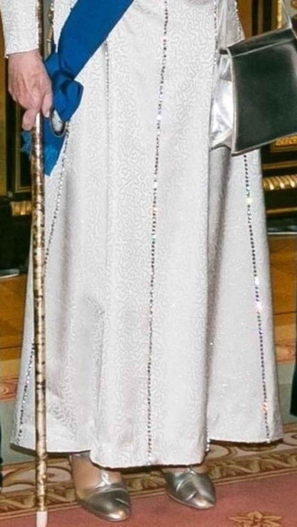 Isabel II, con zapatos y bolso plateados.