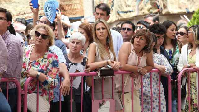 Varias personas esperan a la procesión del Corpus en Toledo el año 2019.