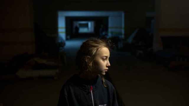 Alina, de 9 años, en el aparcamiento subterráneo de una ciudad ucraniana, donde, junto con sus padres y algunas otras familias, se han refugiado de los ataques aéreos y los bombardeos.