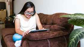 Una mujer con síndrome de Down mirando la pantalla de una tablet.