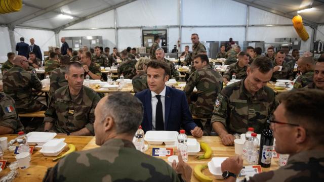 El presidente de Francia, Emmanuel Macron, comiendo con soldados franceses y belgas en la base aérea Mihail Kogalniceanu, cerca de Constanta, en Rumanía.