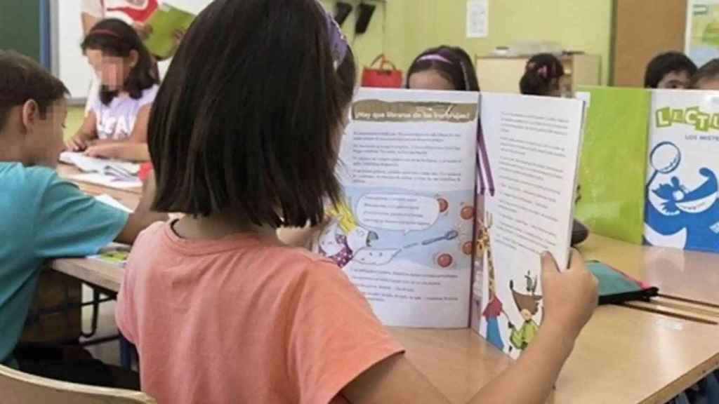 Una niña leyendo en un aula