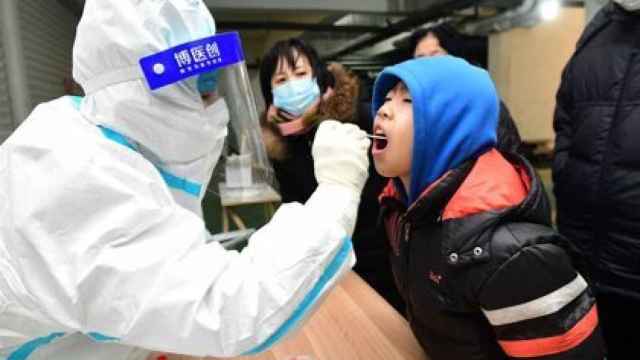 Un sanitario hace un test Covid a un niño en China.