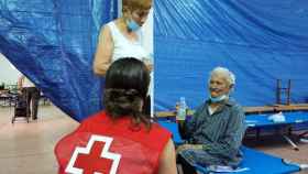 Una voluntaria de Cruz Roja atiende a personas desplazadas durante el incendio en la Sierra de la Culebra