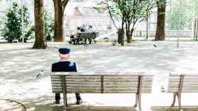 Un anciano solo en el banco de un parque