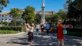 Dos turistas haciendo fotos con el móvil en la Plaza del Triunfo de Sevilla en octubre de 2021.