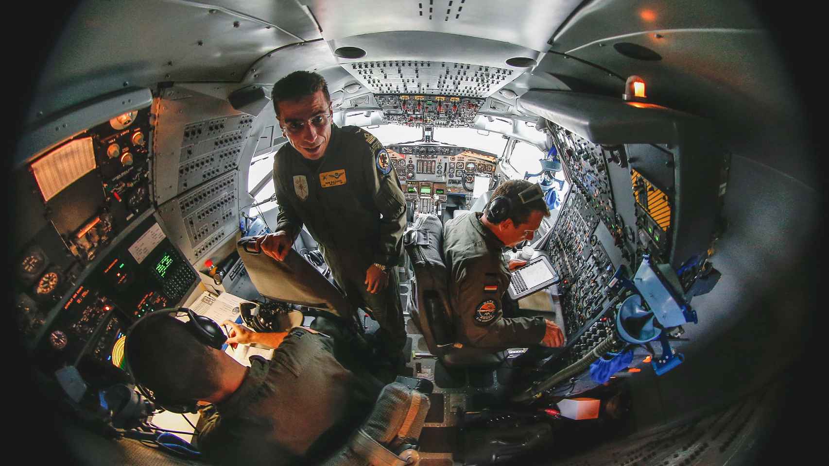 Una foto con ojo de pez de la cabina del E-3A y sus tres tripulantes
