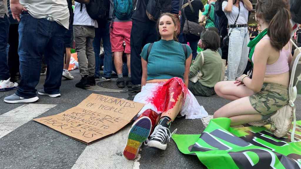Con pintura roja en una falda blanca y las piernas una joven de 33 años se sentó en la Quinta Avenida de Nueva York junto a miles de personas para protestar contra la decisión del Tribunal Supremo.