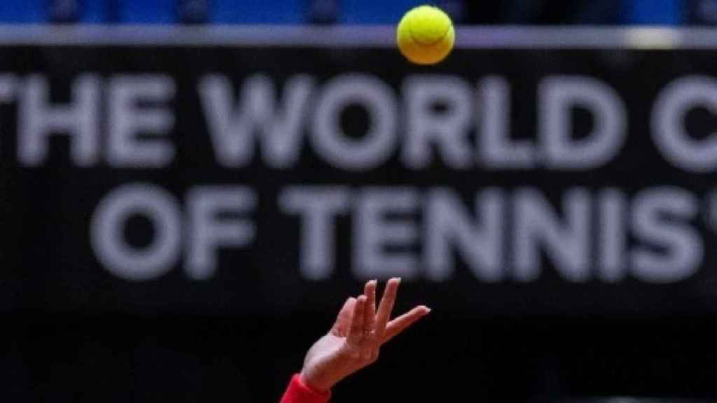 La mano de una tenista tras lanzar la bola para sacar.