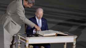 El primer ministro de Baviera, Markur Soeder, indica al presidente de EEUU, Joe Biden, su lugar para la firma del libro de invitados de la región en el aeropuerto de Múnich, este sábado 25 de junio