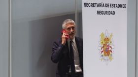 Fernando Grande-Marlaska, habla por teléfono durante su visita a las instalaciones del Centro de Coordinación de la cumbre de la OTAN.