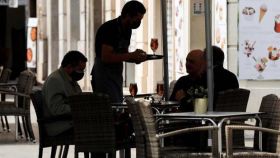 Un camarero sirve una mesa en Alicante, en imagen de archivo.