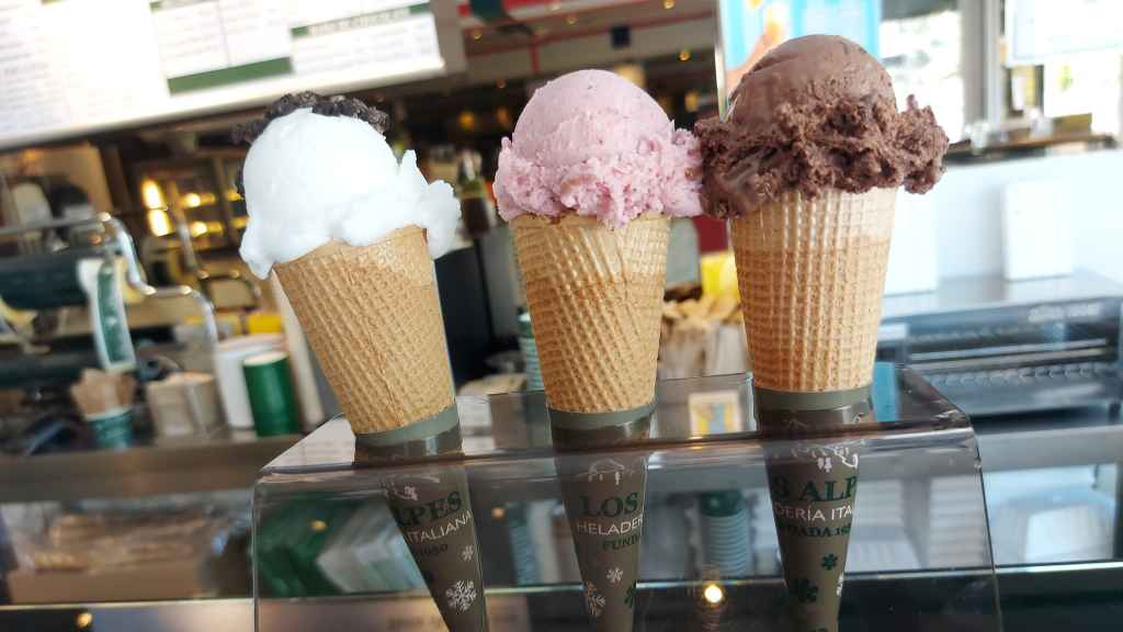 Varios helados preparados en un expositor de una heladería.