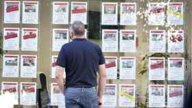 Un hombre observa los anuncios de venta de pisos en una inmobiliaria