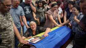 La viuda del soldado ucraniano Volodymyr Kochetov llora sobre su ataúd.