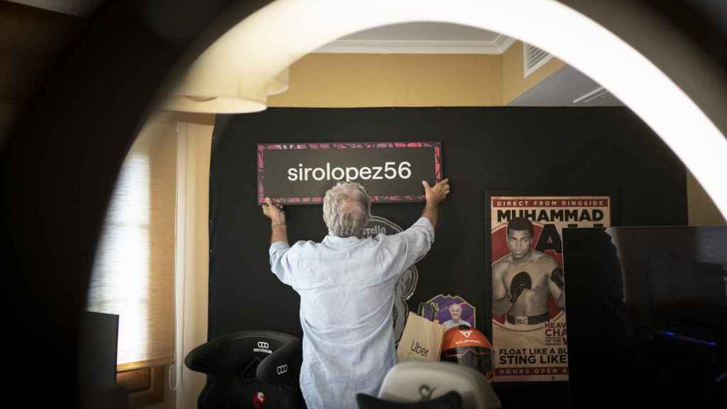 Siro López coloca uno de los carteles en su pared.