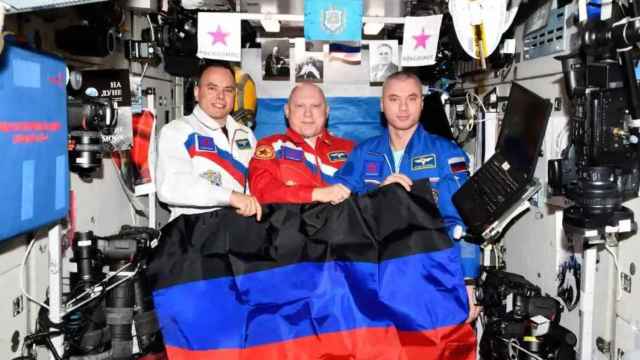 Los tres cosmonautas con la bandera de Lugansk.