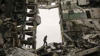 Un residente busca pertenencias en un edificio de apartamentos destruido durante los combates entre las fuerzas ucranianas y rusas en Borodyank.
