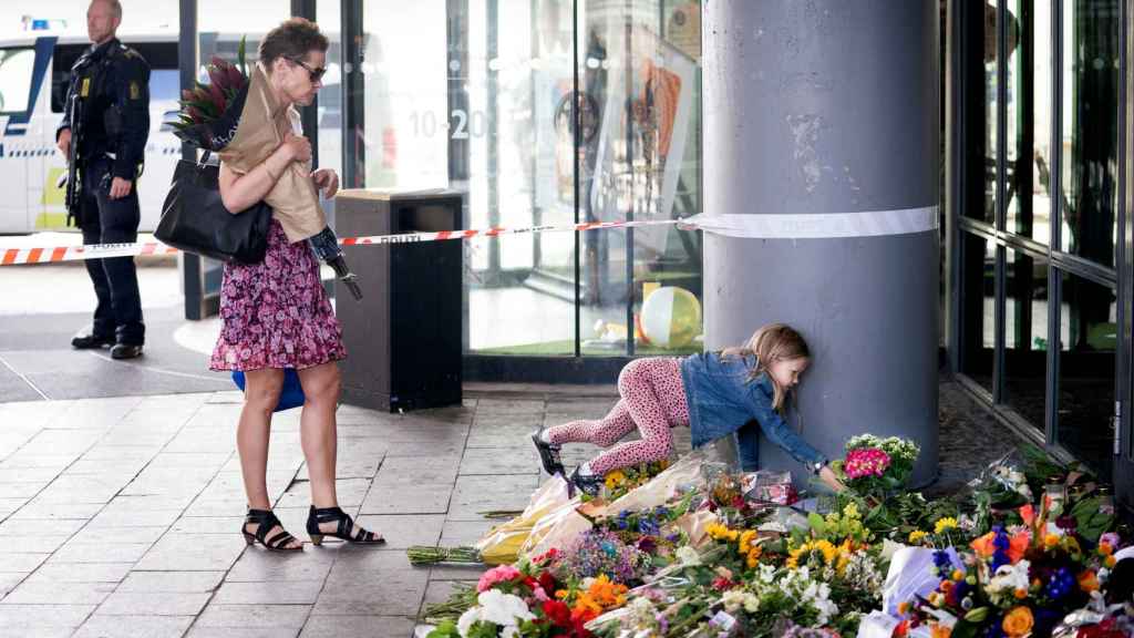 Una niña deja flores en el lugar del tiroteo en Copenhague, Dinamarca.