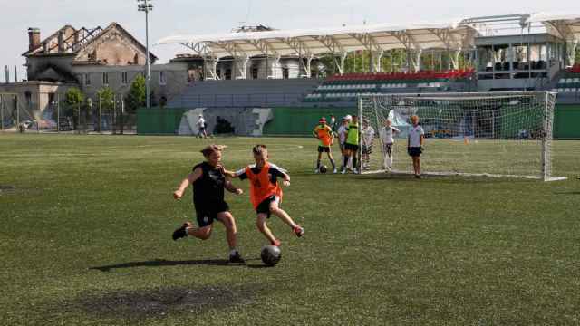 Dos niños disputan un balón en el Champion Stadium.